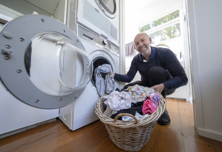 Image of a man loading a front-load washing machine